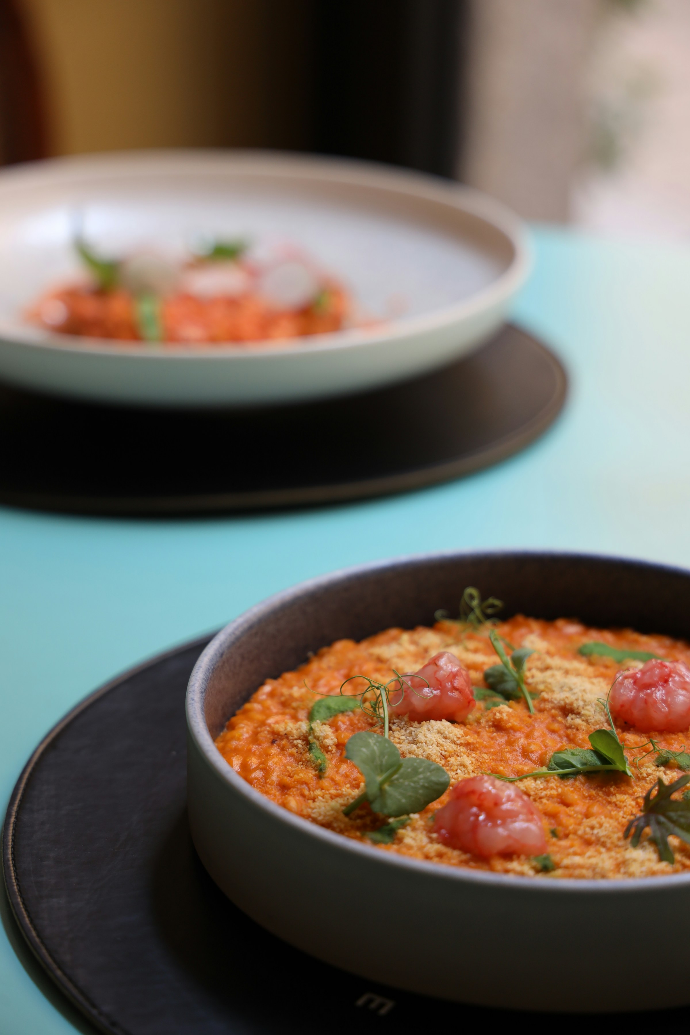 A plated tomato risotto finished with herbs