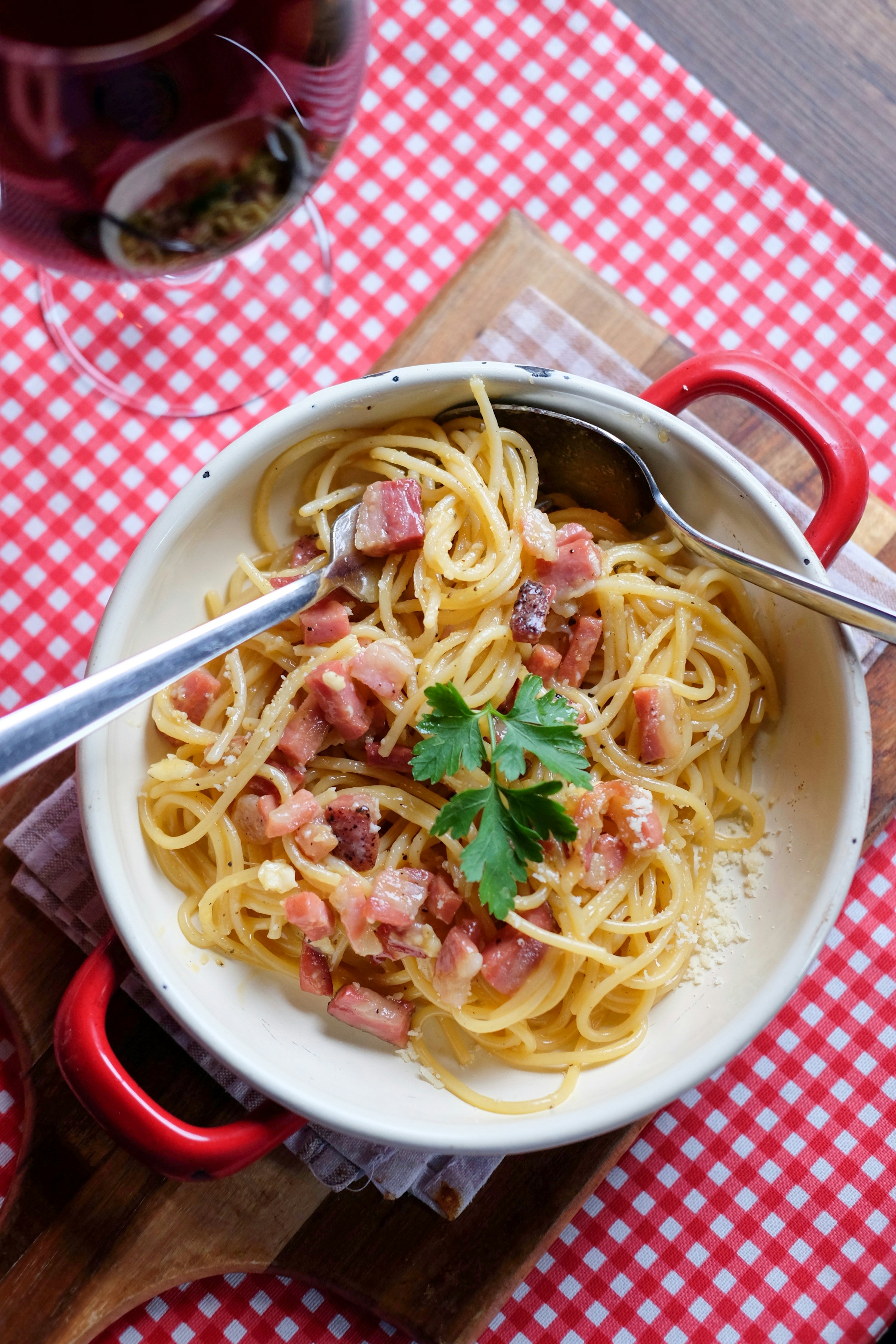 A bowl of spaghetti on a red and white checked tablecloth